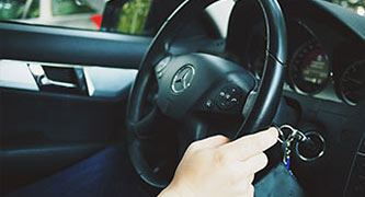 Closeup of a steering wheel inside a vehicle with a driver's hand on the wheel